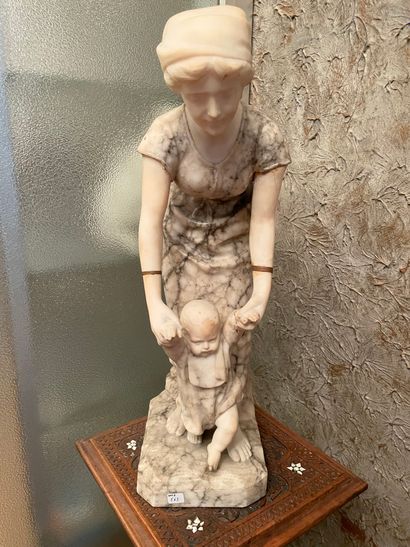 null Sculpture en albâtre représentant une mère tenant un enfant par les mains.
Base...