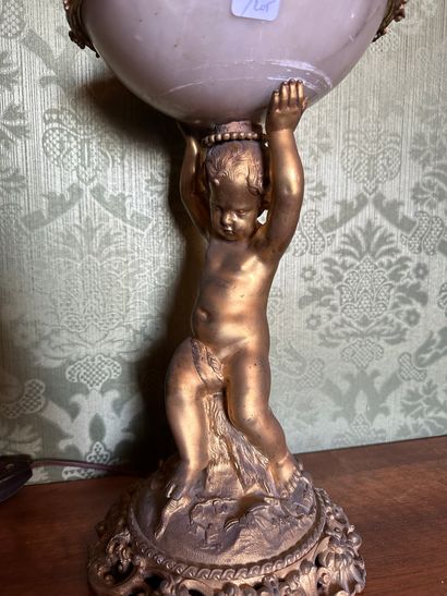 null Lampe en bronze doré sculpté d'un putto assis sur un rocher soutenant un globe...