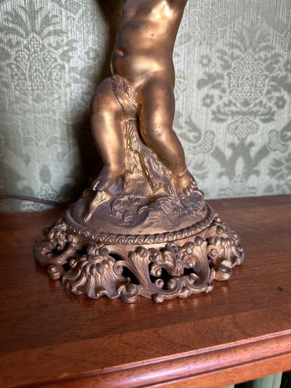 null Lampe en bronze doré sculpté d'un putto assis sur un rocher soutenant un globe...