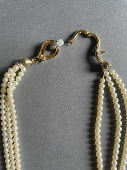 null Necklace of three rows of cultured pearls, enhanced by a two-tone clasp in gold...