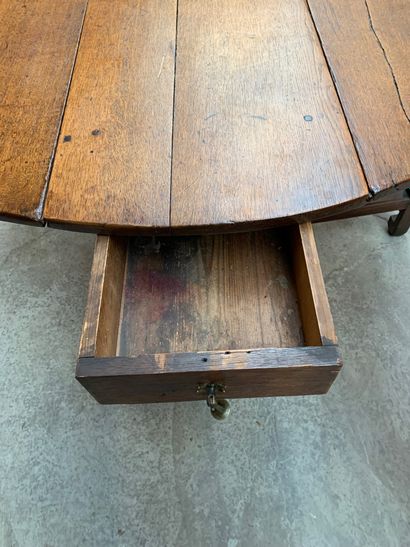 null Table gate-leg en bois naturel à plateau ovale ouvrant par un petit tiroir latéral
72...