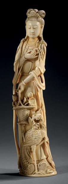 CHINE - XXe siècle STATUETTE en ivoire à patine jaune, jeune femme debout tenant...