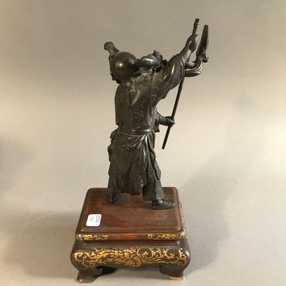 null Statuette en bronze à patine foncée représentant un homme remuant une perche,...