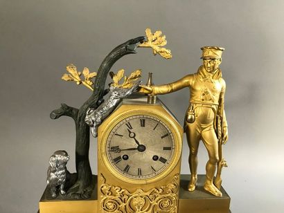 null Pendule de cheminée en laiton et bronze, à décor d'un chasseur montrant un lapin...