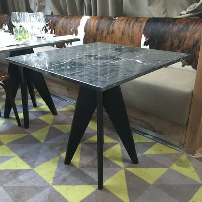 Deux tables carrées en marbre noir, piètement...