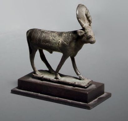 null Statuette votive représentant le taureau Apis coiffé du disque flanqué de l'uræus.
Bronze
Cassure...