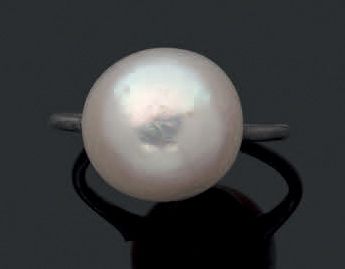  Bague en platine ornée d’une perle fine bouton. Diam. de la perle env. 12,65 mm...