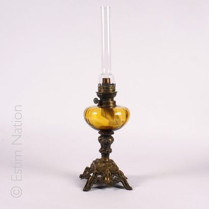 Lampe à pétrole Oil lamp the gilded bronze barrel the colored glass body, with its...