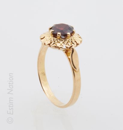 BAGUE OR GRENAT 18K (750/°°) yellow gold ring centered with a round faceted garnet...