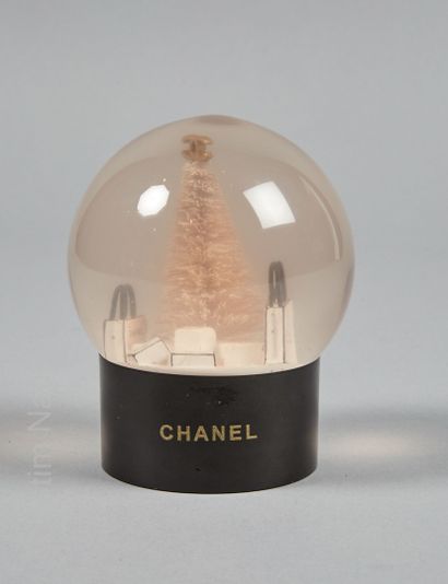CHANEL BOULE A NEIGE en verre et plastique contenant un arbre de Noël et des sacs...