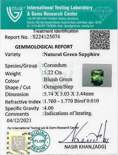 UN SAPHIR SUR PAPIER ET EXAMEN A green sapphire on paper of rectangular shape with...