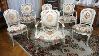 null Trois fauteuils en bois relaqué crème sculpté de fleurettes les pieds cambrés....