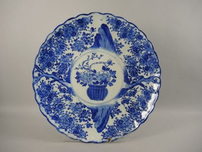 CHINE - PORCELAINE Plat rond en porcelaine à décor imprimé en bleu d'une panier fleuri...