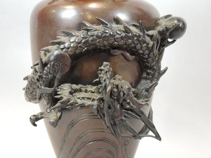 JAPON Vase pansu en bronze à patine brune orné d'un dragon tournoyant en haut-relief.

H...