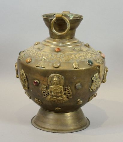 VASE EN LAITON DORÉ Vase pansu à deux anses en laiton doré à décor ciselé de fleurs...