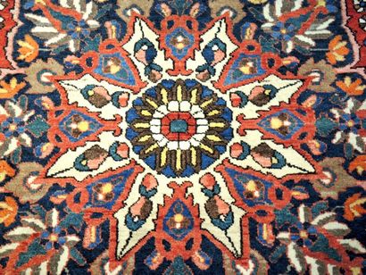 TAPIS Grand tapis en laine à décor de médaillon central en forme de fleur sur fond...