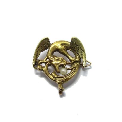 Broche BROCHE en or jaune 18k (750/°°), à décor de chimère serrant dans sa gueule...