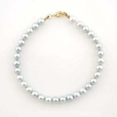 BRACELET PERLES Bracelet composé de perles grises. Fermoir mousqueton en or jaune...