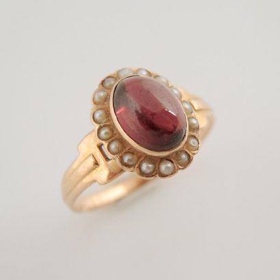 BAGUE OR GRENAT ET PERLES Bague en or rose 18K (750°/00) sertie d'un cabochon de...