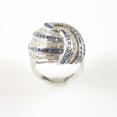 BAGUE DOME SAPHIR DIAMANTS Bague dôme en or gris 18ct 750/°° décorée d'un motif tournoyant...