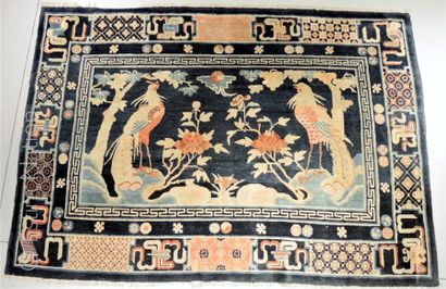 CHINE - XXe siècle Tapis en hauteur en laine sur fond bleu foncé à décor de phénix...