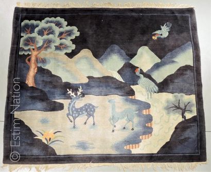 CHINE - XXe siècle Tapis en largeur sur fond bleu foncé, à décor de cerf, biche et...