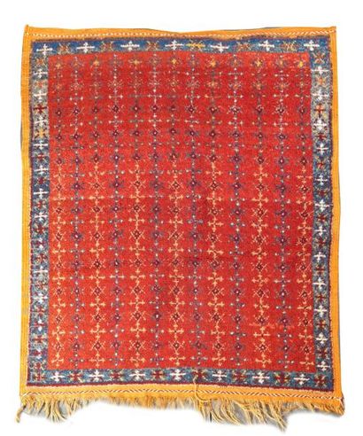 TAPIS MAROCAIN Tapis marocain en laine à fond rouge, la bordure principale à fond...
