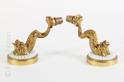 APPLIQUES Paire d'appliques en bronze doré à décor de dauphins. Le globe en opaline...