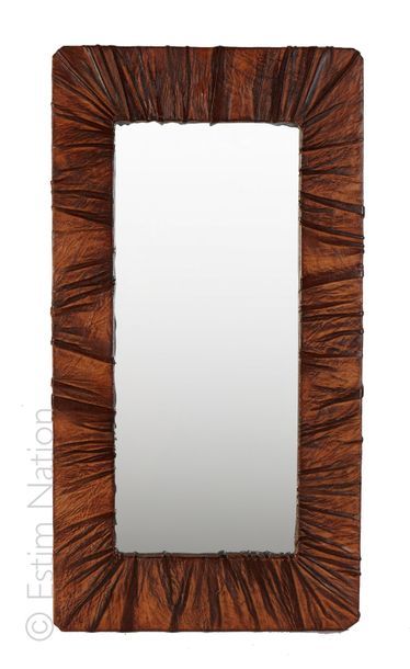MIROIR Miroir de forme rectangulaire présentant un cadre recouvert de cuir plissé....