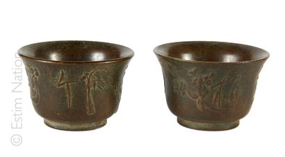 BOLS A SAKE Paire de bols à saké en bronze patiné à décor en relief de motifs feuillagés...
