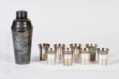 ART DECO - METAL ARGENTE Shaker et huit gobelets en métal argenté à décor strié....