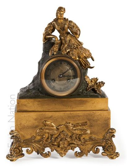 PENDULE A L'ORIENTALE Pendule en bronze à patine dorée et brune à décor d'une femme...