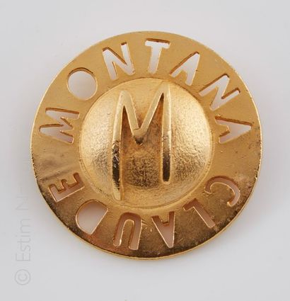 CLAUDE MONTANA PARFUMS Broche en métal doré de forme ronde présentant autour l'inscription...