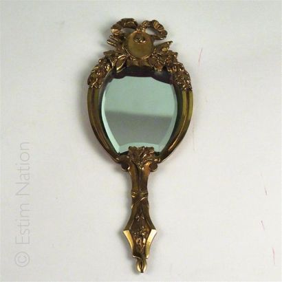 FACE-A-MAIN Face-à-main en bronze doré à décor d'un noeud de ruban, le miroir biseauté
Style...