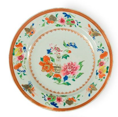 null CHINE de commande. Assiette à décor en émaux polychromes de la famille rose...