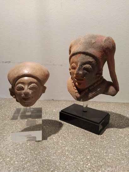 null Set of two fragmentary
heads Beige terracotta with traces of burns and remnants...