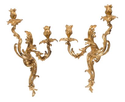  Pair of two lights wall lights in chased and gilded bronze, decorated with rocailles...