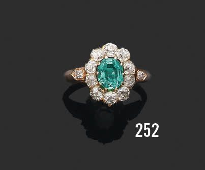 null 18K (750) yellow gold daisy ring set with a rectangular emerald in a setting...