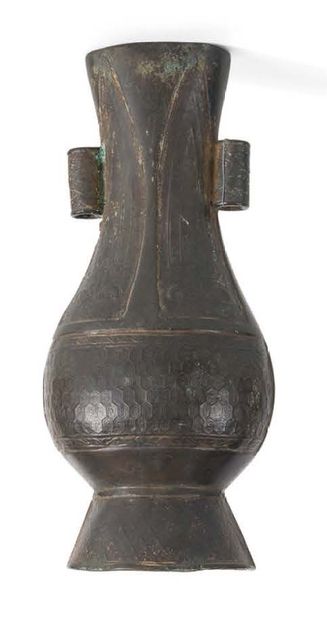 null A small bronze vase with a brown patina, with a pear-shaped body on a high foot,...