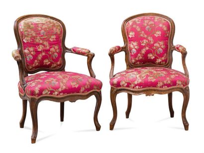  Two cabriolets armchairs in carved and moulded natural wood, the back violonned,...