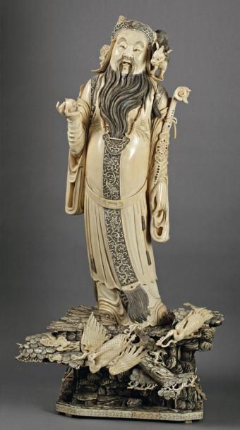 null GRAND OKIMONO en ivoire scupté et gravé à décor de mandarin debout sur un tertre...