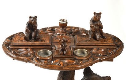 null Writing table in carved and patinated wood. The shaft decorated with bear carrying...