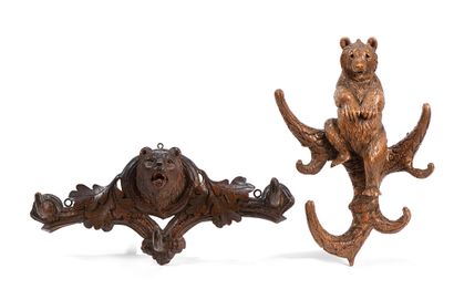 null Two carved and patinated wood coat racks decorated with bear trophy and oak...