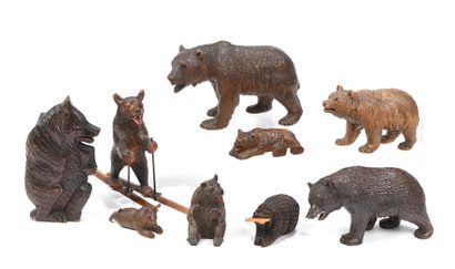 null Nine carved and patinated wooden bears, lying, sitting, or walking, one skiing,...