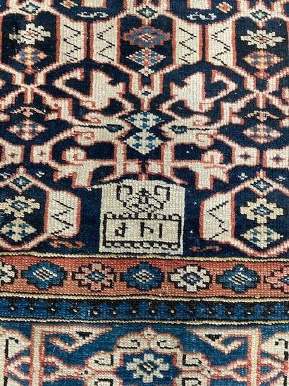 null Ancien tapis du Caucase en laine à fond bleu marine et à décor polychrome géométrique...
