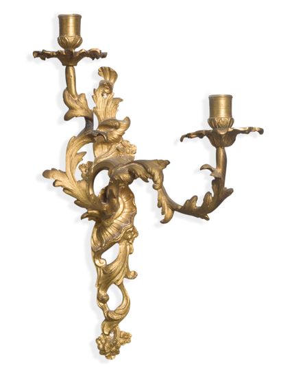 null Pair of sconces with two lights in chased and gilded bronze decorated with foliage...