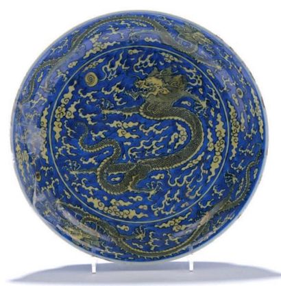 CHINE Coupe en porcelaine à décor en réserve jaune sur fond bleu de trois dragons...