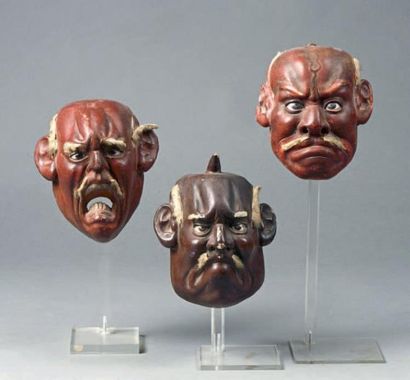 null Suite de trois masques de personnages masculins courroucés, en bois laqués brun...