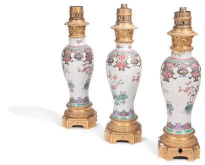 null Suite de trois vases en porcelaine polychrome A décors de fleurs dans des vases....