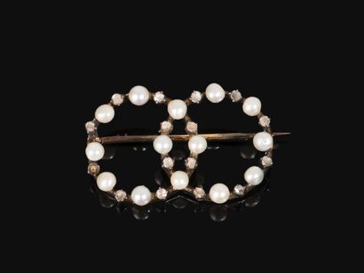 null Broche en or 750 millièmes composée de 2 anneaux ornés de perles et de roses...